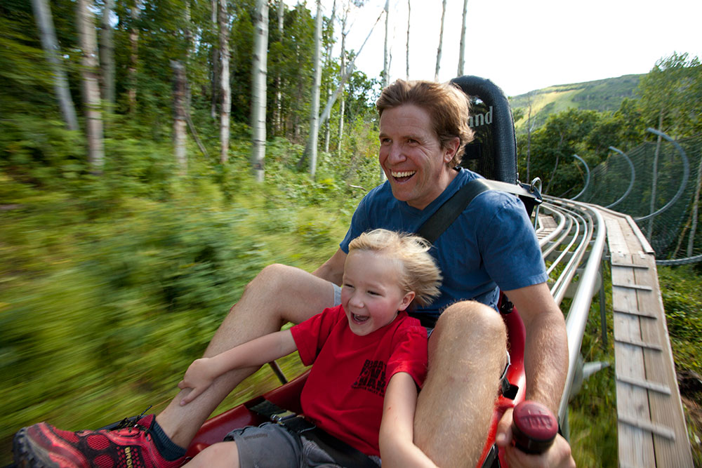 Father and Child Riding Alpine Slide in Summer