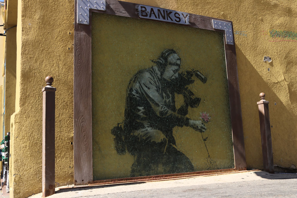 Banksy Camera Man and Flower on wall of Java Cow, Park City Utah