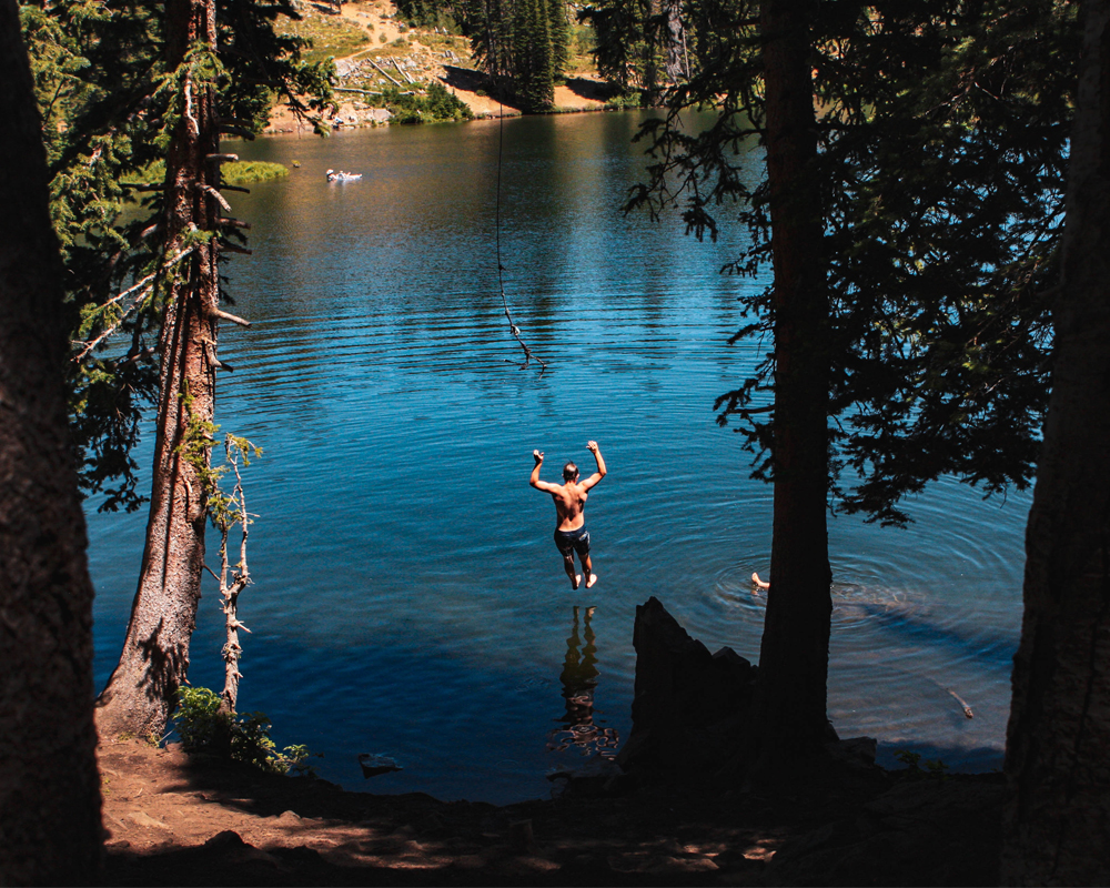 Boy uses rope swing at Bloods Lake