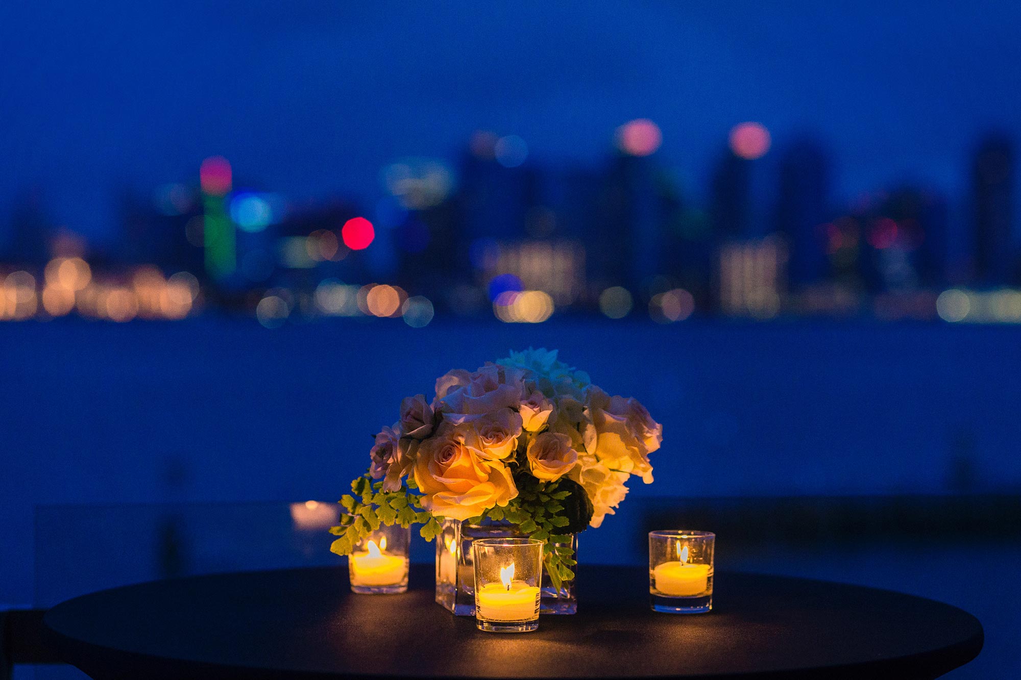 Romantic candlelit dinner with roses overlooking San Diego bay and skyline at dusk