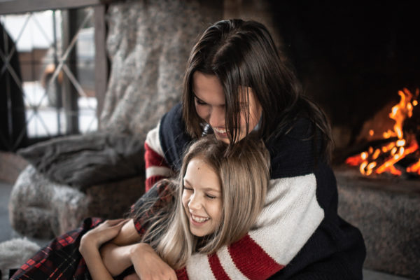 mother and child cuddling up by the fire