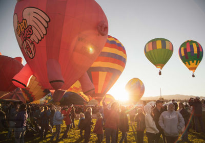 Hot Air Balloons Taking Flight at Dawn with a Crowd of Spectators Looking on