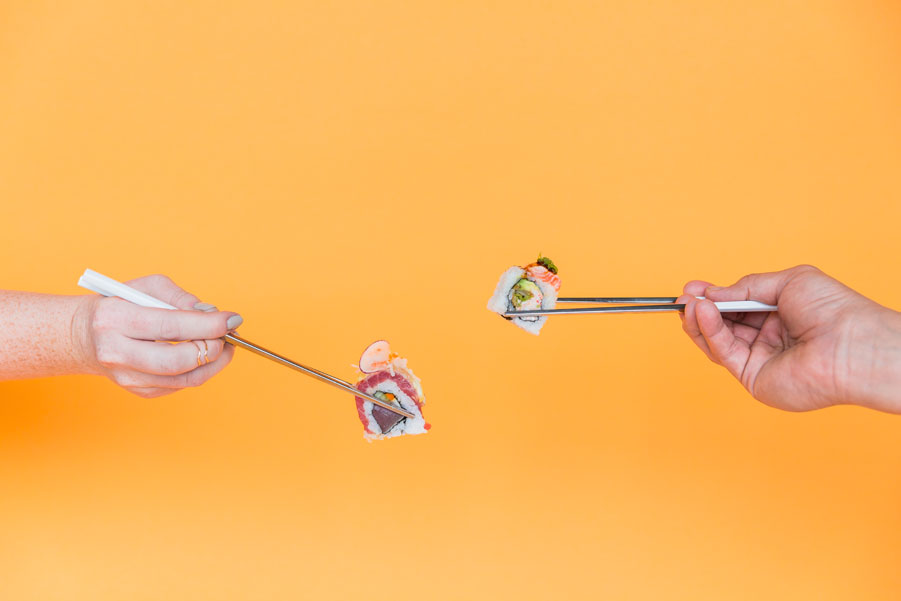 Friends Showing Sushi Between Chopsticks at JRDN in San Diego