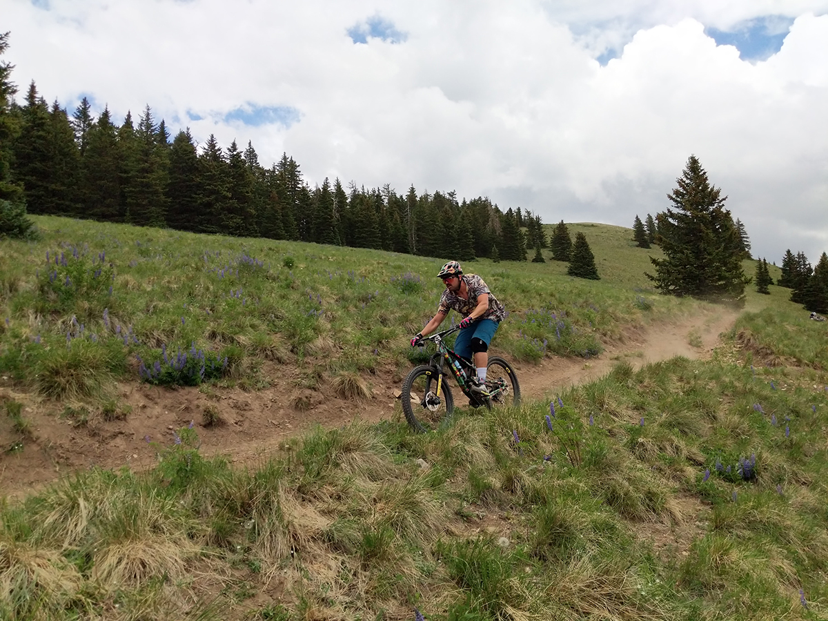 man mountain biking on dirt trail in the mountains