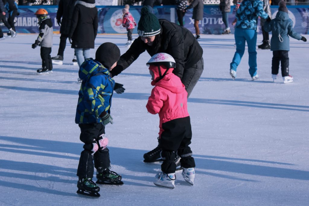 Kids ice skating with parents