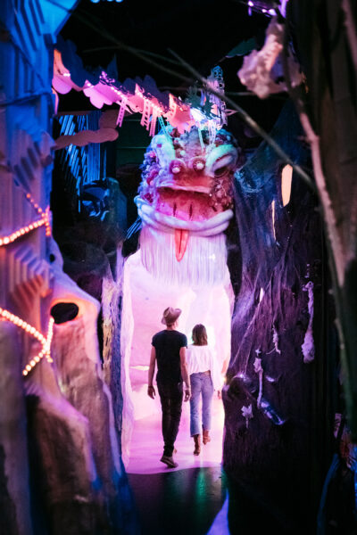 Two People Holding Hands Walking Through Meow Wolf