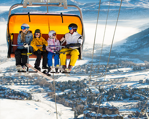 offsquare-chairlift Family in Orange Bubble Lift Overlooking Canyons Village in Park City Utah