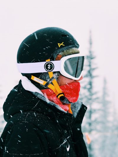 Profile view of a skier in a helmet and mask on snowy day in Park City