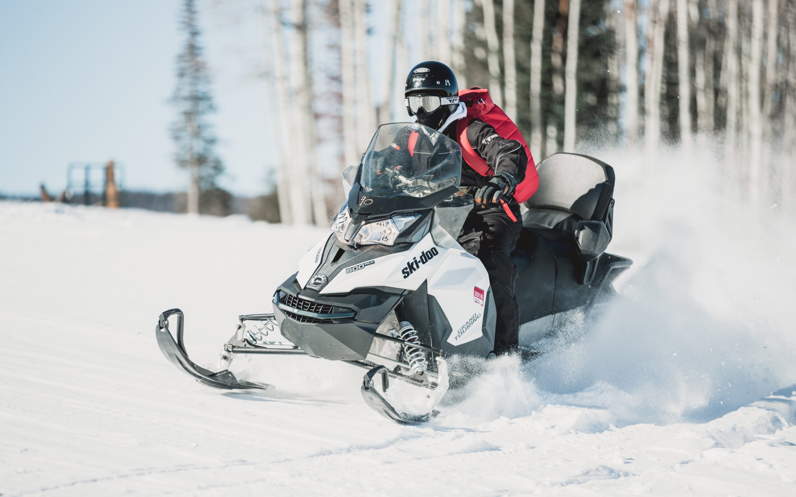 Snowmobiler Riding Across Snow Covered Field