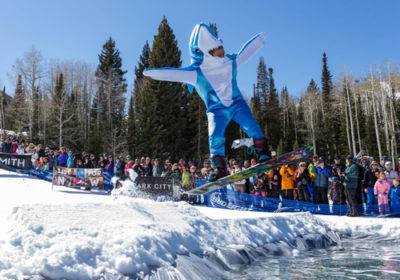 Snowboarder in Shark Suit Jumping Over Icy Pond at Park City Mountain Resort