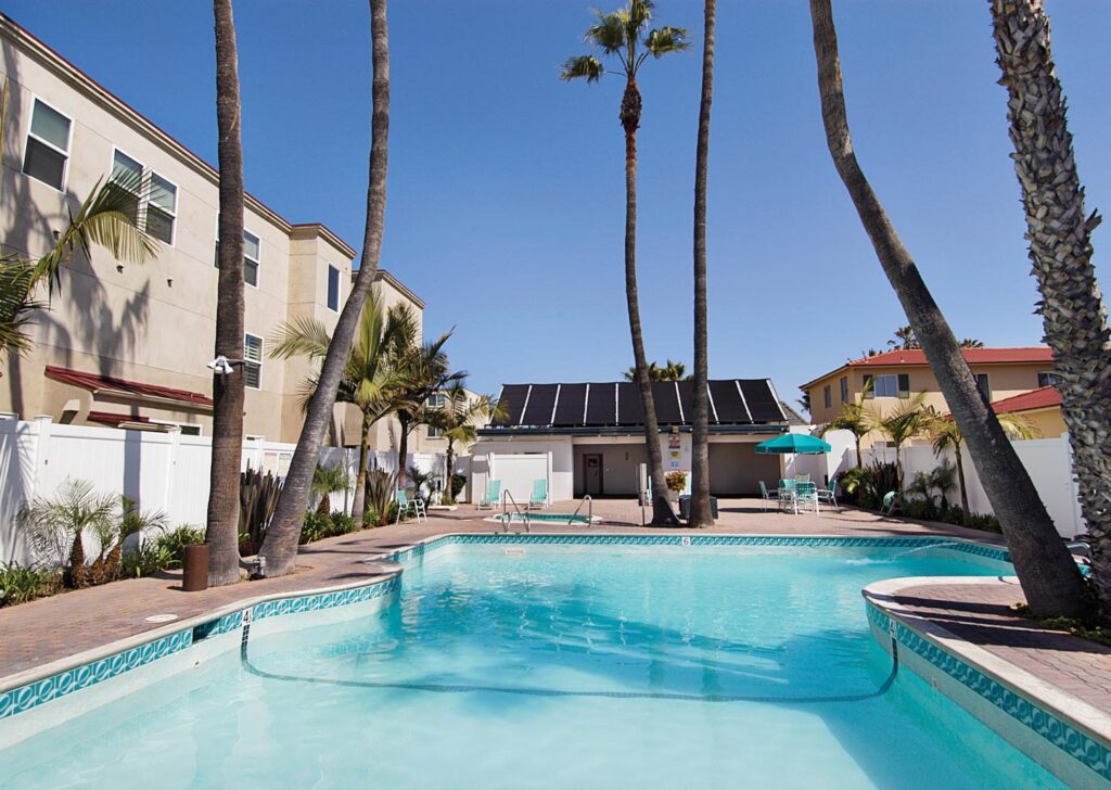 Outdoor Pool with Towering Palm Trees at Capri by the Sea in San Diego, California