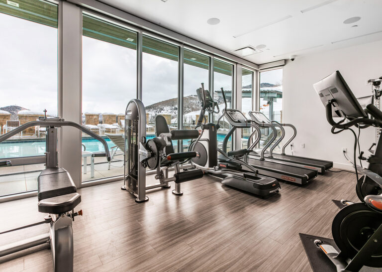 Fitness center looking out large windows to the pool