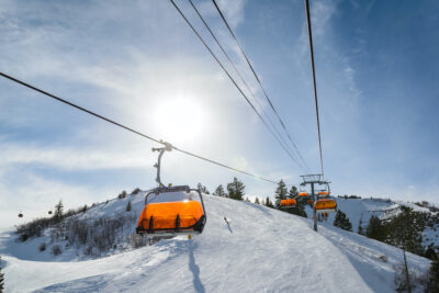 Park City, Utah orange covered ski lifts with sun on sunny day.