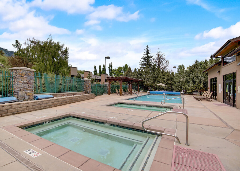 pool deck at park avenue condominiums with two hot tubs and a pool