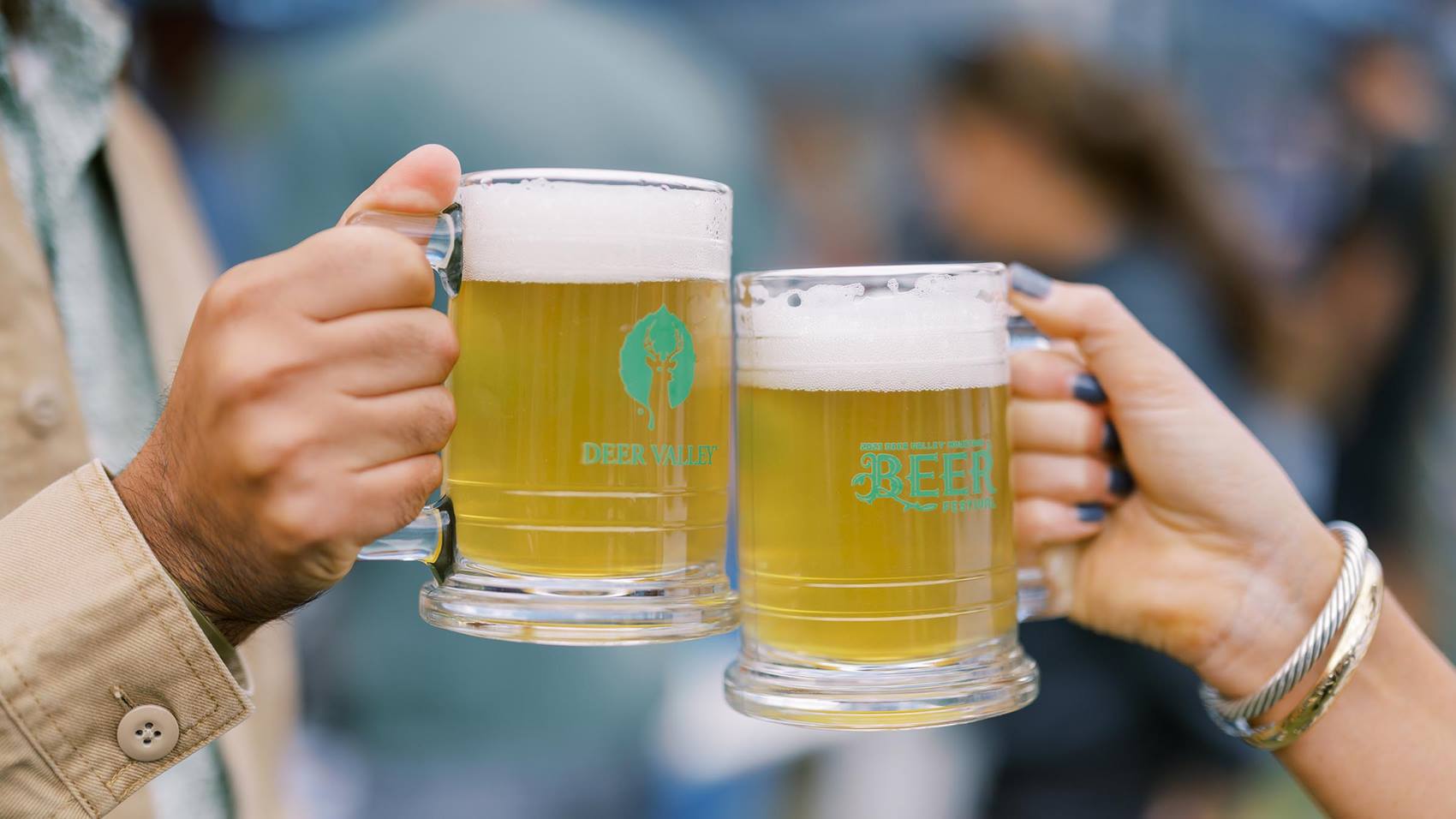 Two guests cheersing with commemorative mugs at the Deer Valley Mountain Beer Festival